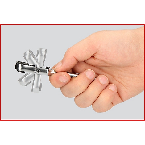 Hand hält eine Ratsche; die Bewegung wird durch Grautöne visualisiert.